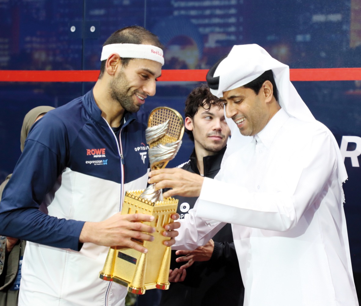 Qatar Tennis, Squash and Badminton Federation President Nasser Al Khelaifi presents the QTerminals Qatar Classic trophy to Mohamed ElShorbagy.