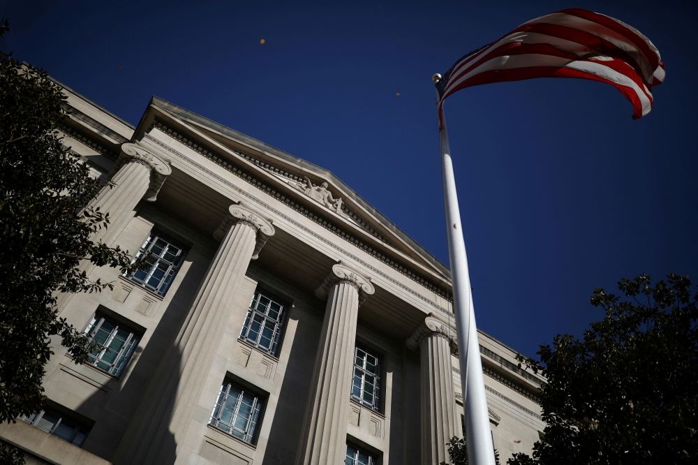 An American flag waves outside the US Department of Justice Building in Washington, on December 2, 2020.  File Photo / Reuters
