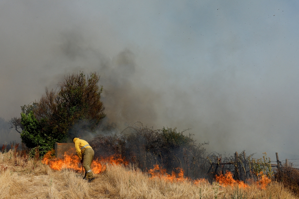 File photo: Firefighters working to extinguish a wildfire in Spain. Pic by: Borja Suarez / Reuters