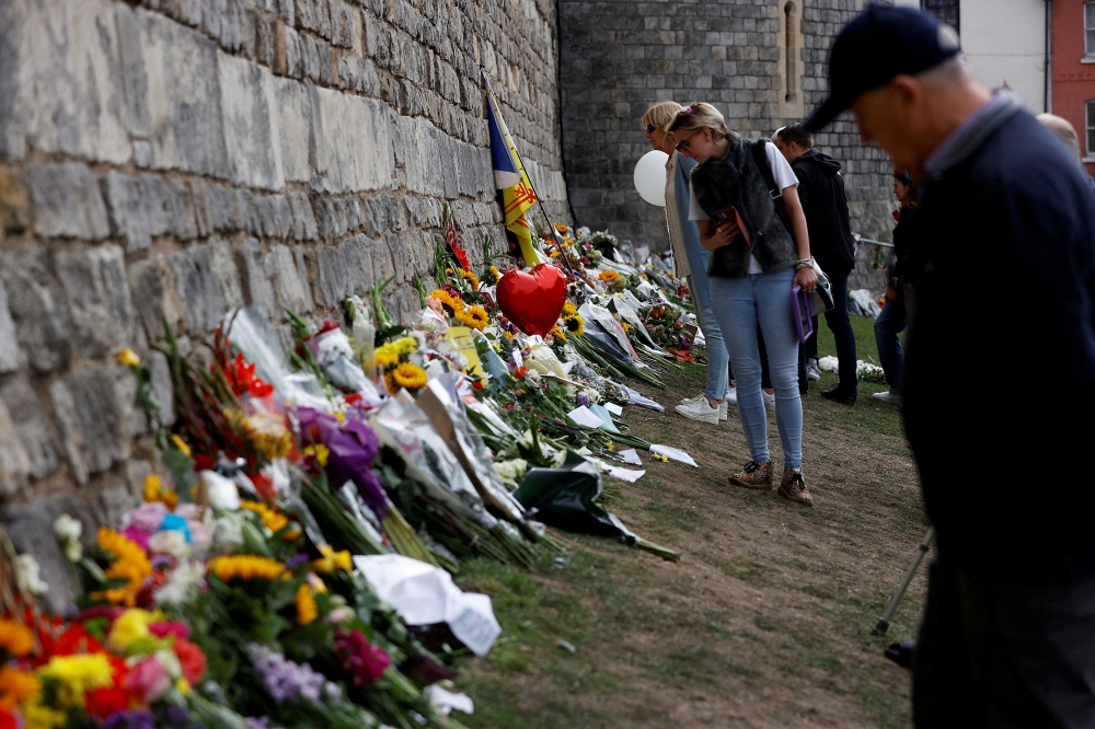 People look at the floral tributes, following the funeral of Britain's Queen Elizabeth, in Windsor, Britain September 20, 2022. REUTERS/Peter Nicholls