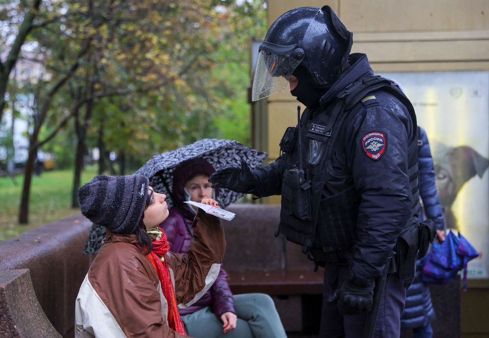 A person shows a passport to a Russian law enforcement officer during a rally, after opposition activists called for street protests against the mobilisation of reservists ordered by President Vladimir Putin, in Moscow on September 24, 2022. REUTERS/REUTERS PHOTOGRAPHER