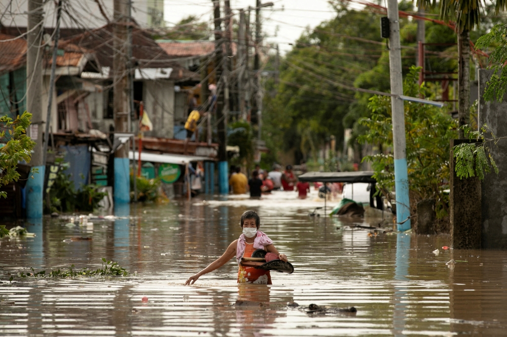 Residents wade through waist-deep flood waters after Super Typhoon Noru, in San Miguel, Bulacan province, Philippines, September 26, 2022. REUTERS/Eloisa Lopez