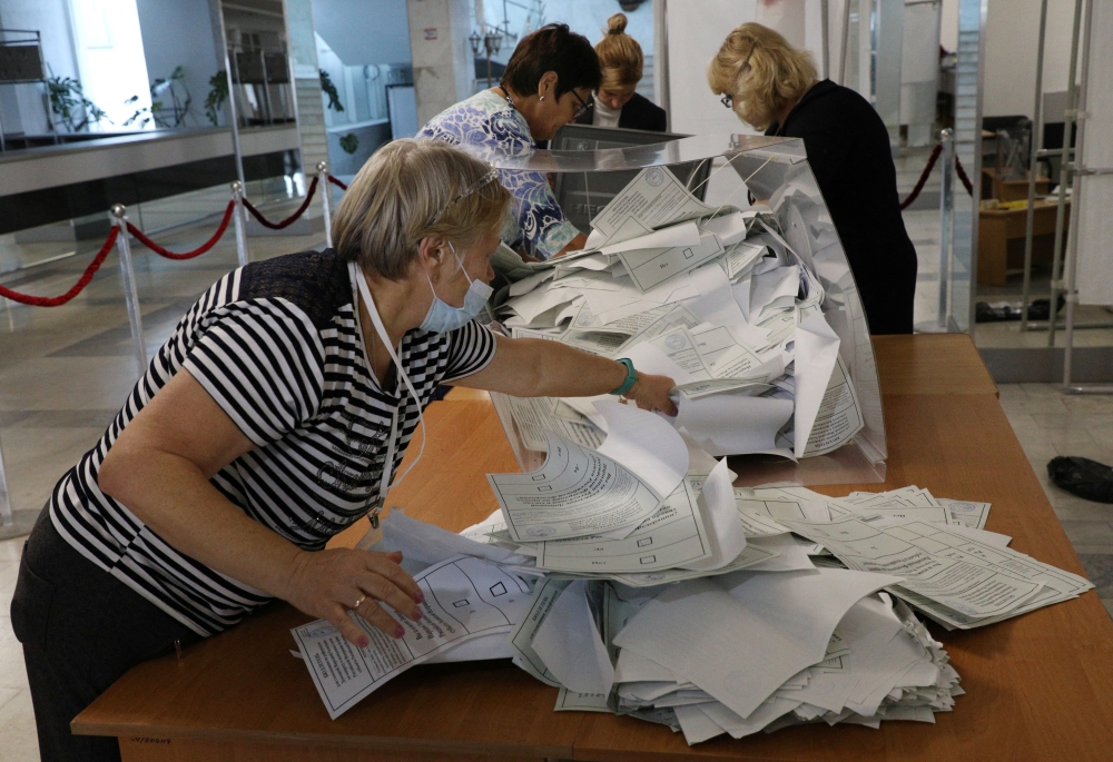 Members of an electoral commission empty a ballot box at a polling station following a referendum on the joining of Russian-controlled regions of Ukraine to Russia, in Sevastopol, Crimea, on September 27, 2022. (REUTERS/Alexey Pavlishak)