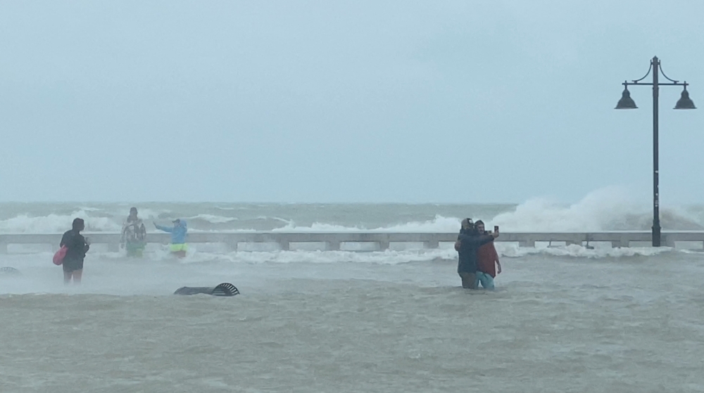 People take pictures as they gather at Key West pier as Hurricane Ian approaches, in Key West, Florida, U.S., September 27, 2022, in this screen grab taken from a social media video. Gwen Filosa/via Reuters 