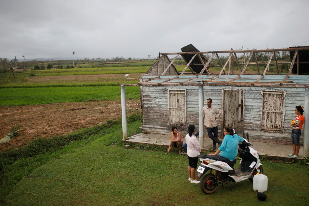 A family speaks in front of their destroyed home in the aftermath of Hurricane Ian in El Cafetal, Cuba, on September 27, 2022. REUTERS/Alexandre Meneghini