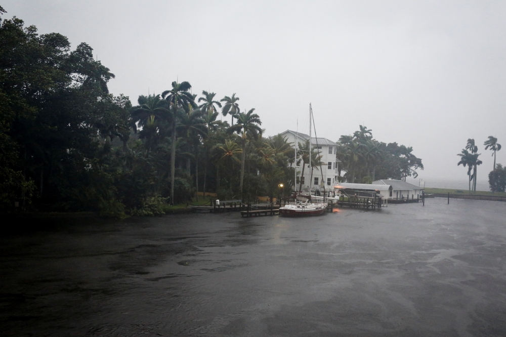 :A sailboat is seen moored at a house ahead of Hurricane Ian, in Fort Myers, Florida, on September 28, 2022. REUTERS/Marco Bello