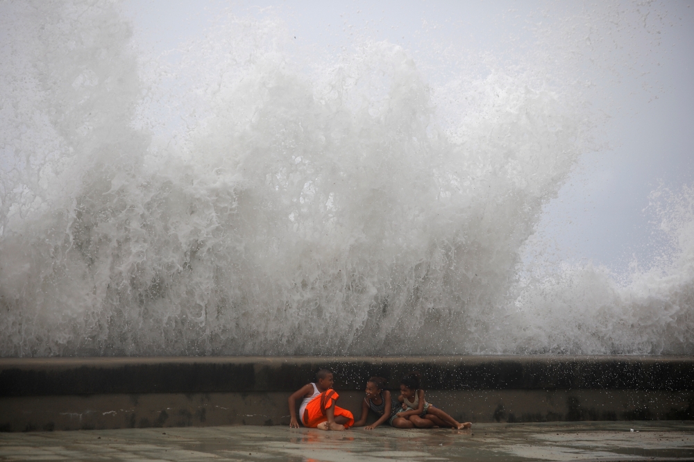 :Children play with waves at the seafront in the aftermath of Hurricane Ian in Havana, Cuba, on September 28, 2022. REUTERS/Alexandre Meneghini