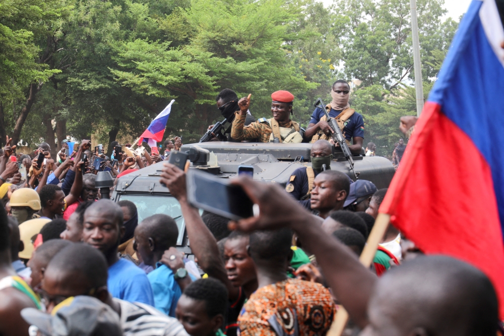 Burkina Faso's self-declared new leader Ibrahim Traore is welcomed by supporters holding Russian's flags as he arrives at the national television standing in an armoured vehicle in Ouagadougou, Burkina Faso, on October 2, 2022. (REUTERS/Vincent Bado) 