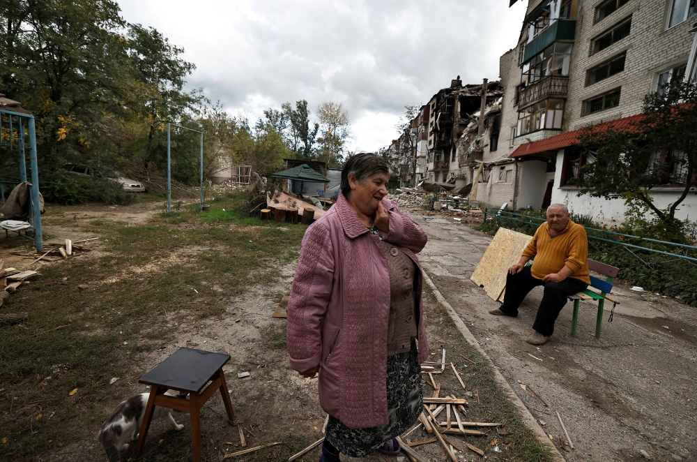 A woman reacts as she stands outside a building that was damaged by a Russian missile amid Russia's attack on Ukraine, in Svyatohirsk, in Donetsk region, Ukraine, on October 3, 2022. (REUTERS/Zohra Bensemra)