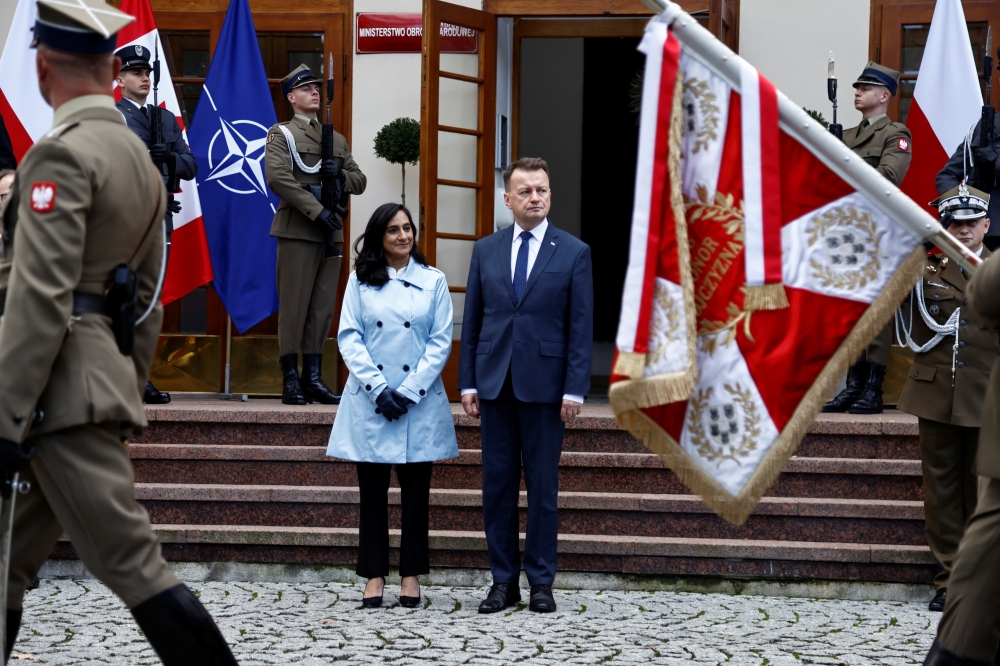 Canadian Defence Minister Anita Anand and her Polish counterpart Mariusz Blaszczak review the honor guard during a welcoming ceremony in Warsaw, Poland October 11, 2022. REUTERS/Kuba Stezycki