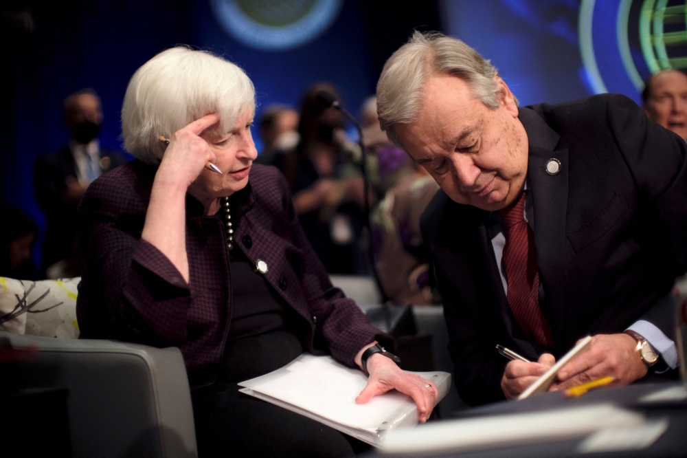 UN Secretary General Antonio Guterres kneels to speak with U.S. Treasury Secretary Janet Yellen at the Annual Meetings of the International Monetary Fund and World Bank in Washington, US, on October 14, 2022. REUTERS/James Lawler Duggan
 