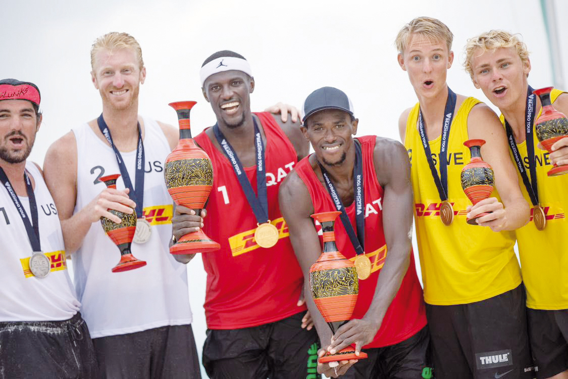 Qatar’s Cherif Younousse and Ahmed Tijan celebrate on the podium with silver and bronze winners of the Volleyball World Beach Pro Tour Maldives Challenge.