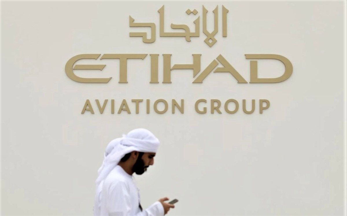 A visitor walks past the Etihad Aviation Group logo on display during the fifth day of Dubai Air Show in Dubai, United Arab Emirates, November 21, 2019. (REUTERS/Christopher Pike)