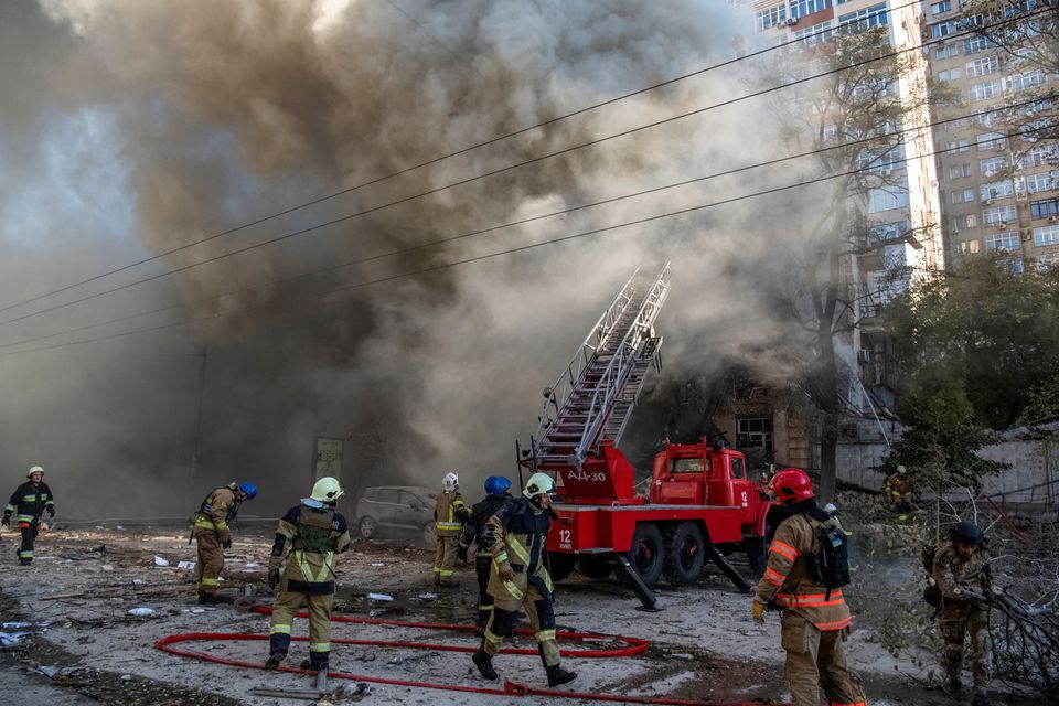 Firefighters help a local woman evacuate from a residential building destroyed by a Russian drone strike, which local authorities consider to be Iranian-made unmanned aerial vehicles (UAVs) Shahed-136, amid Russia's attack on Ukraine, in Kiev, Ukraine, on October 17, 2022. REUTERS/Vladyslav Musiienko