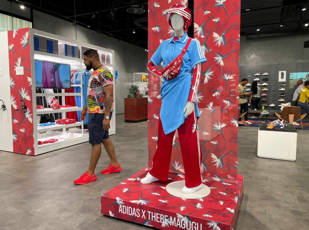 A customer walks past clothing by South African luxury fashion designer, Thebe Magugu, who has showcased his designs in Paris and London, at an Adidas store in Johannesburg, South Africa, October 22, 2022. REUTERS/Taurai Maduna NO RESALES. NO ARCHIVES