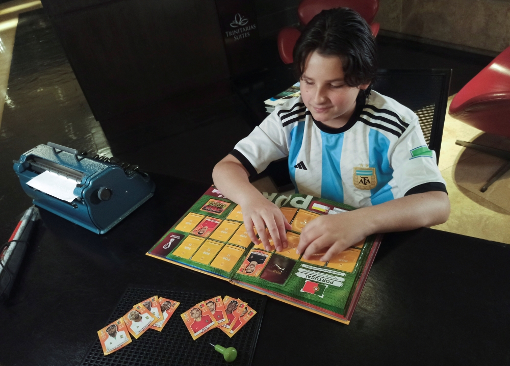 Sebastian Filoramo, 12, a visually impaired boy who adapted the FIFA World Cup Qatar 2022 Panini card album to Braille, checks his album in Barquisimeto, Venezuela, November 8, 2022. REUTERS/Keren Torres 