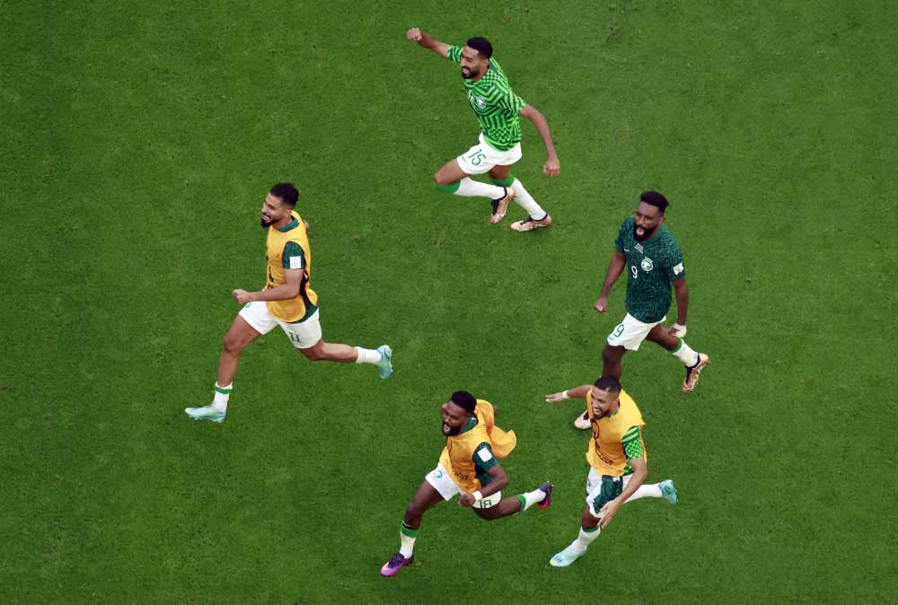 November 22, 2022 Saudi Arabia's Saleh Al-Shehri, Nawaf Al Abid and teammates celebrate after the match REUTERS/Peter Cziborra