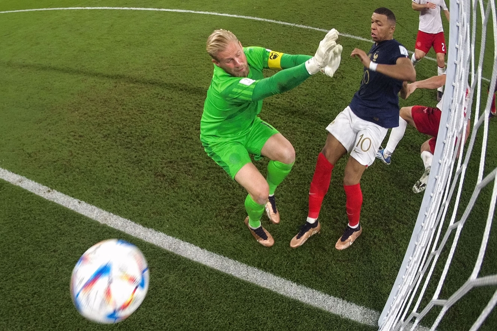 France's forward #10 Kylian Mbappe scores the team' second goal past Denmark's goalkeeper #01 Kasper Schmeichel during the Qatar 2022 World Cup Group D football match between France and Denmark at Stadium 974 in Doha on November 26, 2022. (Photo by Giuseppe CACACE / AFP)