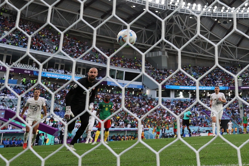 Cameroon's forward #10 Vincent Aboubakar (C) scores his team's second goal past Serbia's goalkeeper #23 Vanja Milinkovic-Savic (2nd L) . (Photo by Adrian Dennis / AFP)