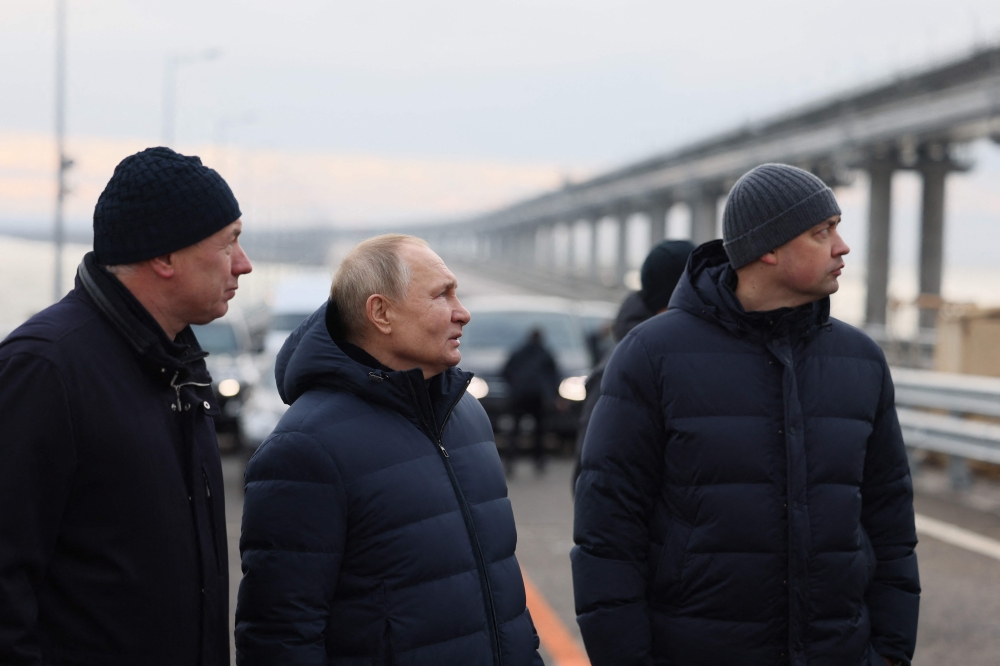 Russian President Vladimir Putin, flanked by Deputy Prime Minister Marat Khusnullin (left), visits the Kerch Strait Bridge, also known as the Crimean Bridge on December 5, 2022. The bridge, that links Russia's mainland with the Crimean Peninsula, was damaged by an attack on October 8, 2022. (Photo by Mikhail Metzel / SPUTNIK / AFP) / 