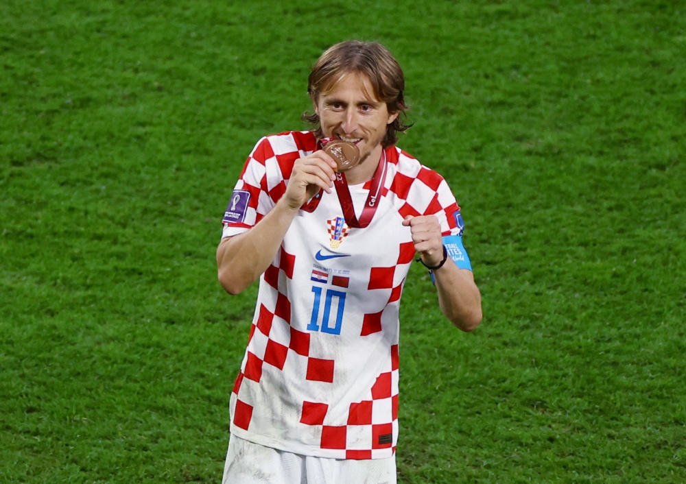 Croatia's Luka Modric bites his medal as he celebrates Croatia finishing in third place at the end of the FIFA World Cup Qatar 2022 third-place playoff against Morocco at the Khalifa International Stadium, Doha, Qatar, on December 17, 2022.   REUTERS/Kai Pfaffenbach
