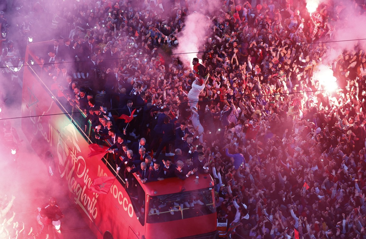 Morocco players are pictured on a bus as their fans celebrate with flares during a parade as the team return from Qatar. REUTERS