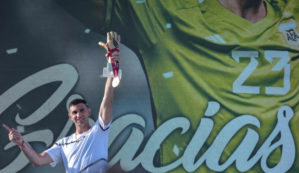 The goalkeeper of the Argentine soccer team Emiliano Martinez, holds a gold medal and gold glove trophy awarded by FIFA during a tribute to him, in Mar del Plata, Argentina, on December 22, 2022, upon his return to his hometown after winning the Qatar 2022 World Cup tournament. (Photo by Mara Sosti / AFP)