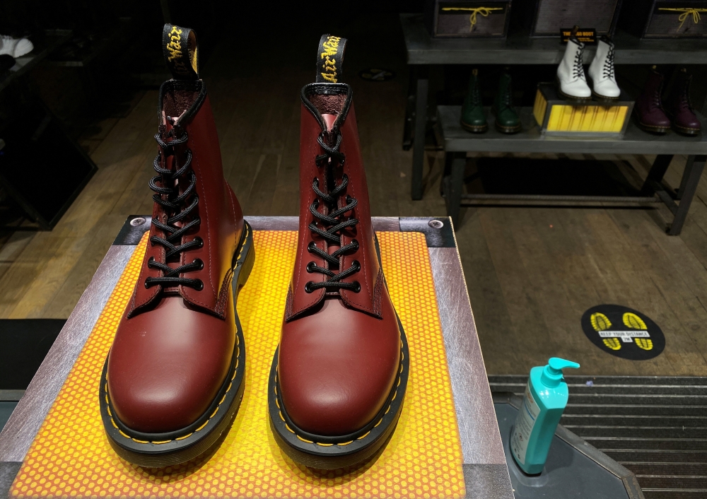 A pair of Dr. Martens boots seen through the window of a Dr Martens shop in London, Britain, September 17, 2020. REUTERS/Simon Newman/File Photo