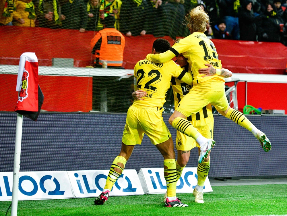 Dortmund's players celebrate a goal during the German Bundesliga match between Bayer 04 Leverkusen and Borussia Dortmund in Leverkusen, western Germany on January 29, 2023. (Photo by SASCHA SCHUERMANN / AFP)