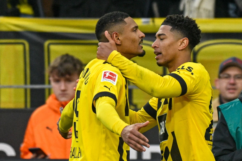 Dortmund's French forward Sebastien Haller (L) celebrates scoring the 3-1 goal with teammate Dortmund's English midfielder Jude Bellingham during the German first division Bundesliga football match between Borussia Dortmund v SC Freiburg in Dortmund, western Germany, on February 4, 2023. SASCHA SCHUERMANN / AFP