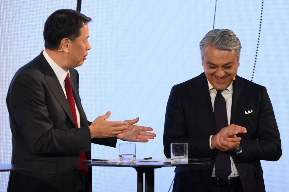 Renault chief executive officer Luca de Meo (R) laughs as Nissan chief executive officer Makoto Uchida speaks during a press conference in London on February 6, 2023. (Photo by Daniel LEAL / AFP)