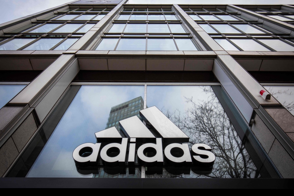 In this file photo taken on March 29, 2020 the logo of German sporting goods company Adidas is pictured at one of the company's outlets in Berlin, Germany. Photo by Odd ANDERSEN / AFP