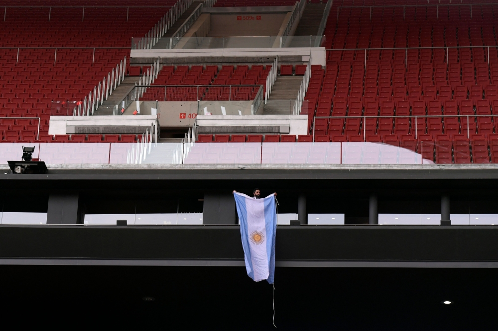 A person unfolds an Argentinian flag prior to the Spanish League football match between Club Atletico de Madrid and Athletic Club Bilbao at the Wanda Metropolitano stadium in Madrid, on February 19, 2023. (Photo by OSCAR DEL POZO / AFP)