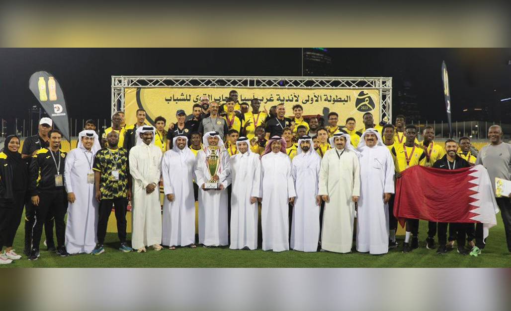 Qatar SC players and officials celebrate with the champions trophy.