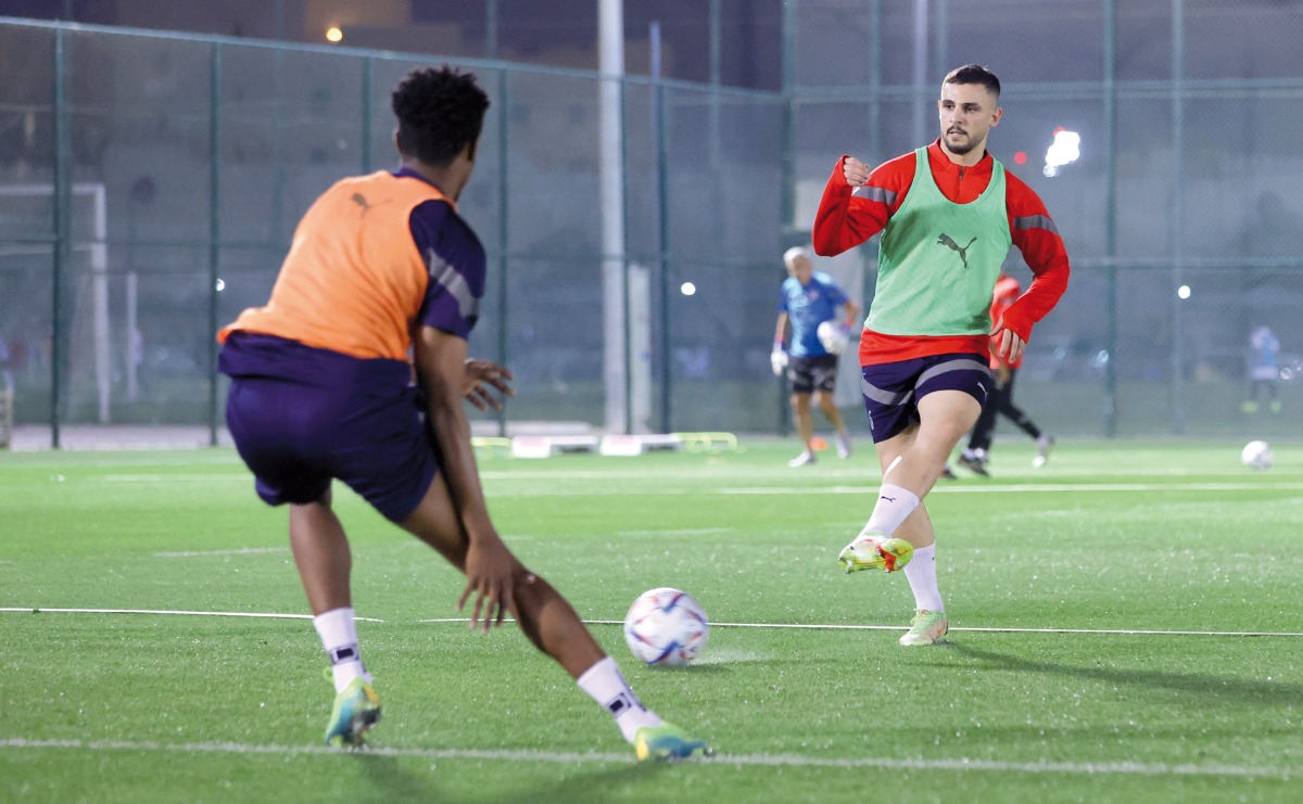 Al Duhail's Bassam Al Rawi with a teammate during a training session.