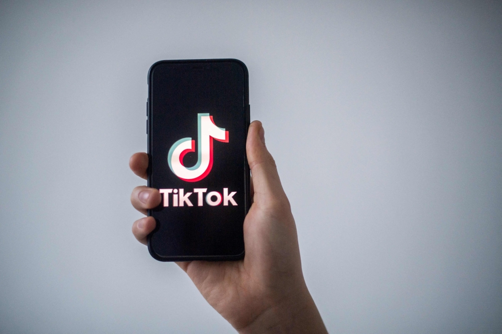 In this file illustration photo taken on January 21, 2021 in Nantes, western France, a man shows a smartphone with the logo of Chinese social network Tik Tok. Photo by LOIC VENANCE / AFP