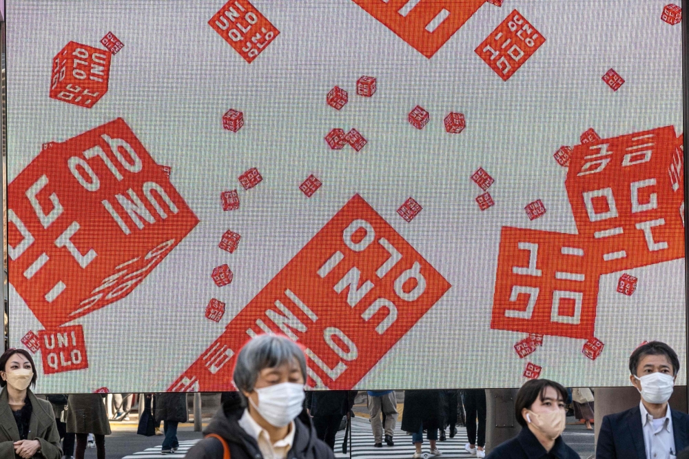  In this file photo taken on January 11, 2023, pedestrians walk in front of a Uniqlo store operated by Japan's Fast Retailing in Tokyo. Photo by Philip FONG / AFP