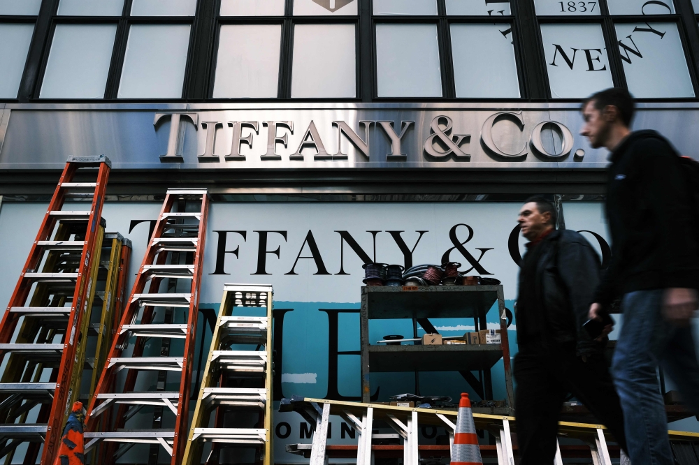 In this file photo taken on November 25, 2019, people walk by the Tiffany & Co flagship store along Fifth Avenue in the Manhattan borough of New York City. Photo by SPENCER PLATT / GETTY IMAGES NORTH AMERICA / AFP