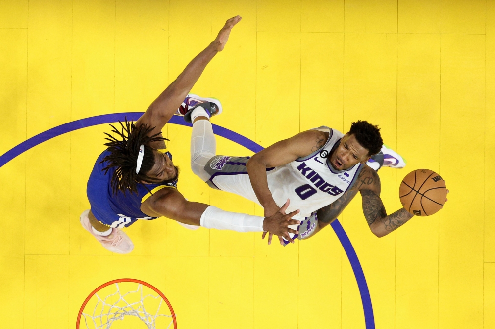 Malik Monk #0 of the Sacramento Kings goes up for a shot on Kevon Looney #5 of the Golden State Warriors during Game Six of the Western Conference First Round Playoffs at Chase Center on April 28, 2023 in San Francisco, California. (Photo by EZRA SHAW / GETTY IMAGES NORTH AMERICA / Getty Images via AFP)
