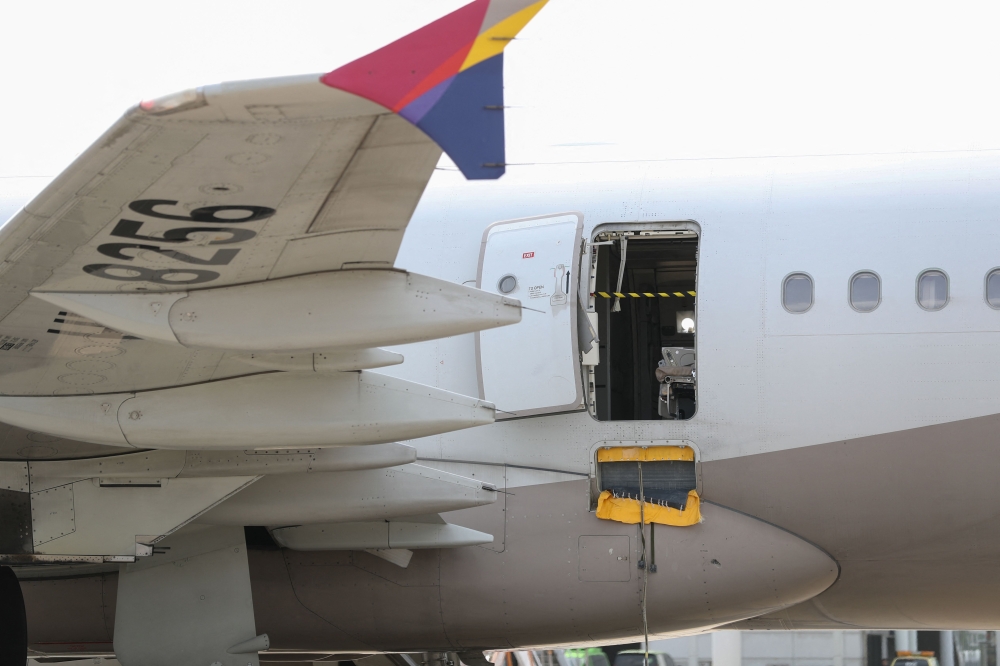 An opened door of an Asiana Airlines plane is seen at Daegu International Airport in Daegu on May 26, 2023, after it was manually opened by a passenger. (Photo by Yonhap/ AFP) 