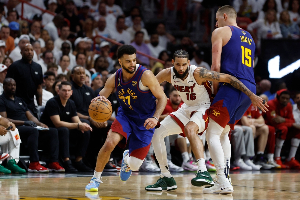 Jamal Murray #27 of the Denver Nuggets dribbles past a screen set by Nikola Jokic #15 against Caleb Martin #16 of the Miami Heat during the fourth quarter in Game Three of the 2023 NBA Finals at Kaseya Center on June 07, 2023 in Miami, Florida.  Photo by Mike Ehrmann /  Getty Images via AFP)
