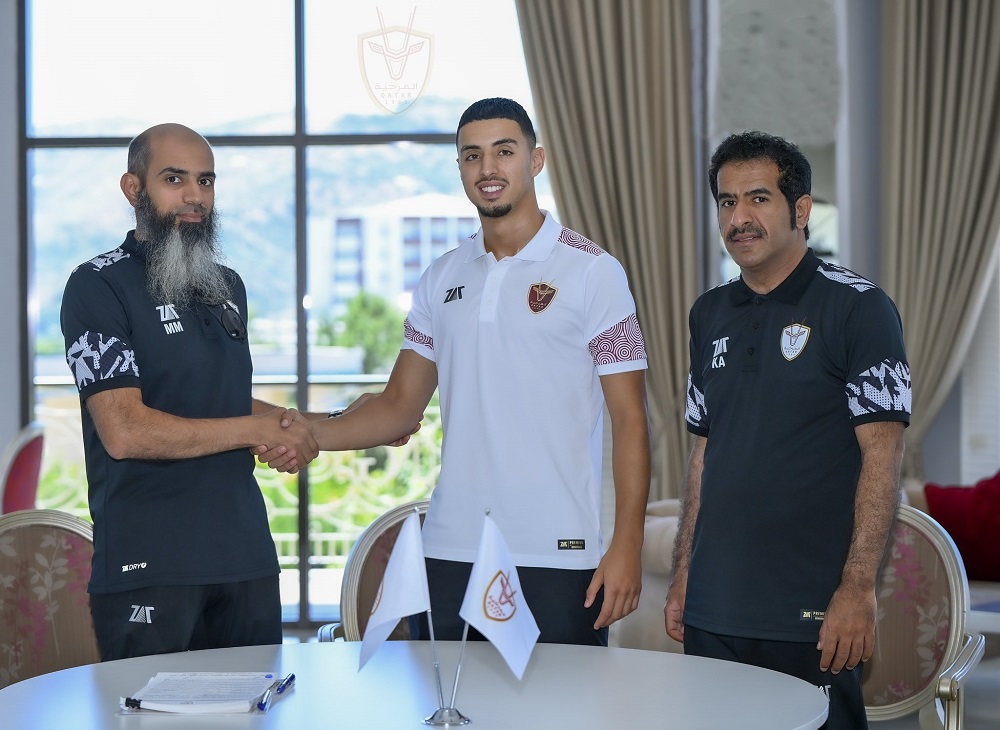 Dutch striker Naoufal Bannis (centre) with Al Markhiya officials after signing the contract.