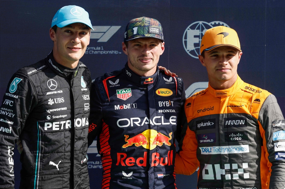 Mercedes' British driver George Russell (L), Red Bull Racing's Dutch driver Max Verstappen and McLaren's British driver Lando Norris pose after taking the leading positions in the qualifying session at The Circuit Zandvoort, ahead of the Dutch Formula One Grand Prix, in Zandvoort on August 26, 2023. (Photo by SIMON WOHLFAHRT / AFP)
