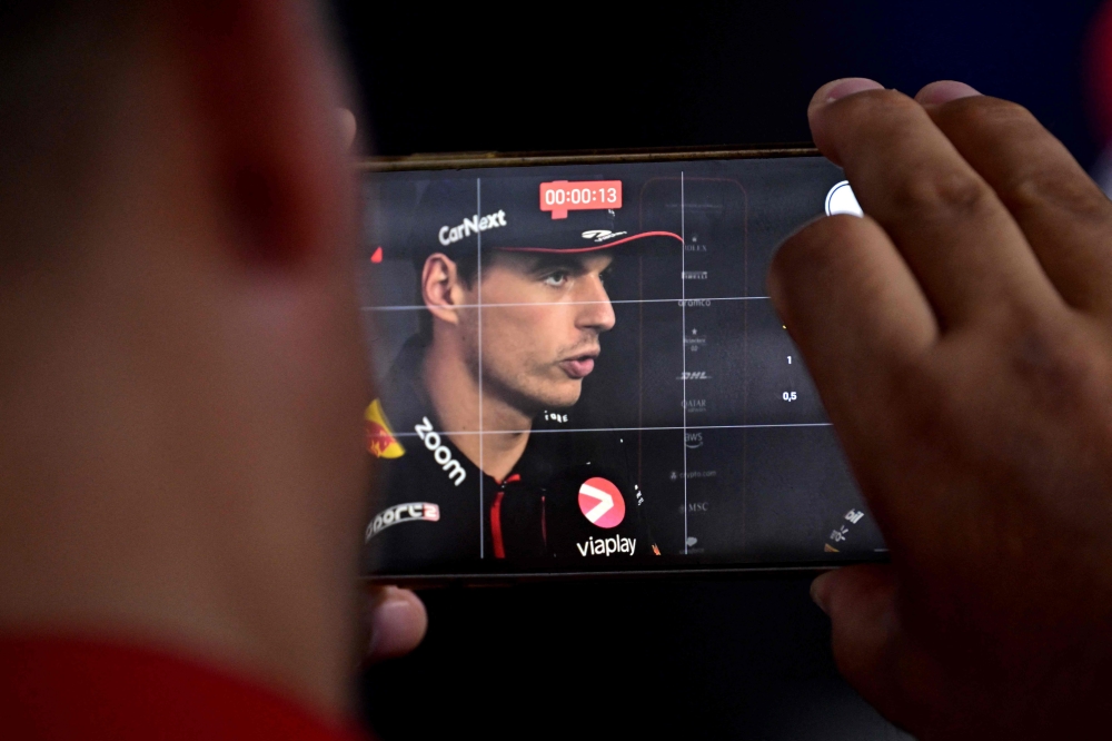 Red Bull Racing's Dutch driver Max Verstappen speaks during an interview as someone photographs him on a mobile phone at the Monza Circuit ahead of the Italy's Formula One Grand Prix, in Monza northern Italy, on August 31, 2023. Photo by Ben Stansall / AFP