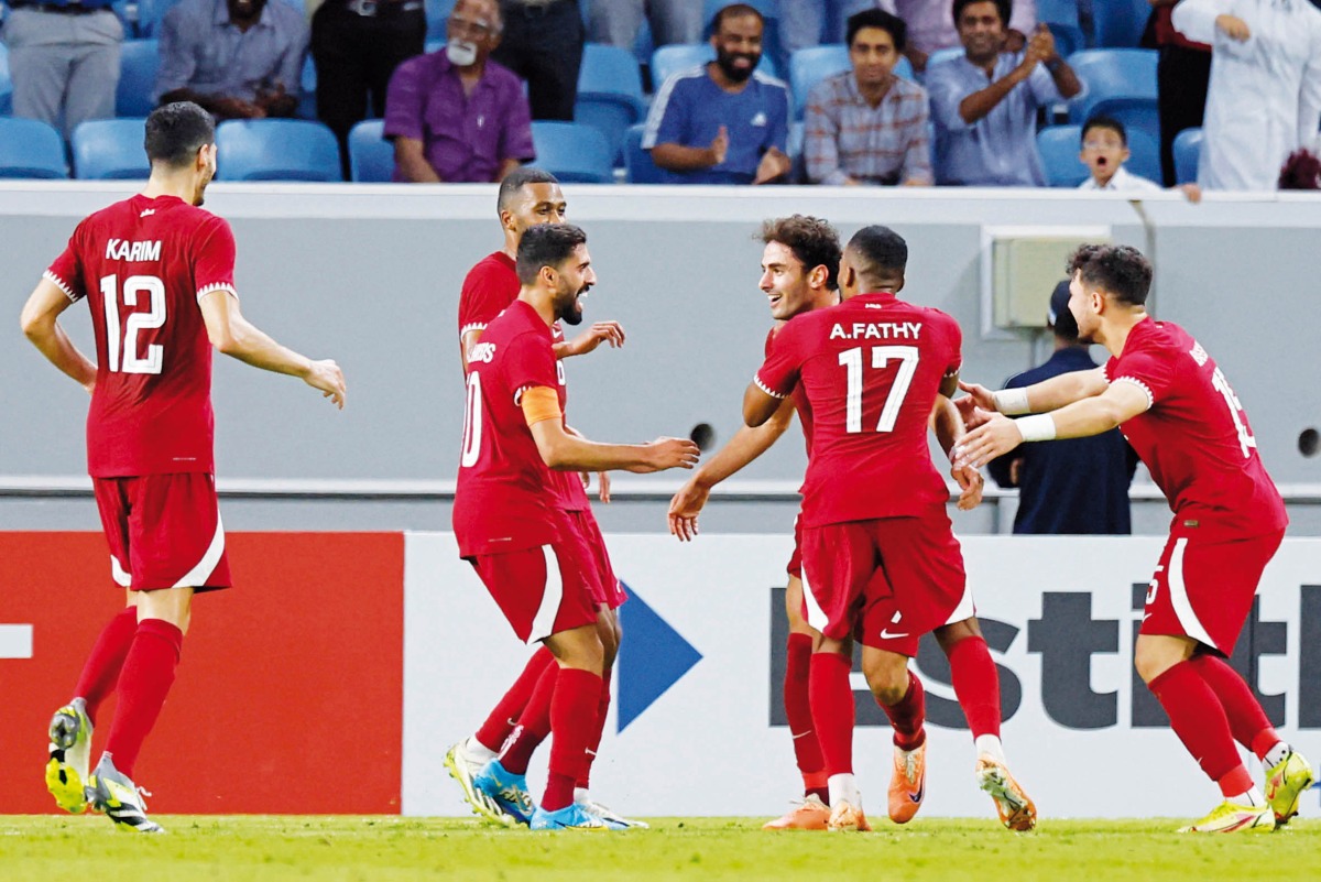 Qatar’s forward Ahmed Alaaeldin celebrates with teammates after scoring a goal against Russia. AFP