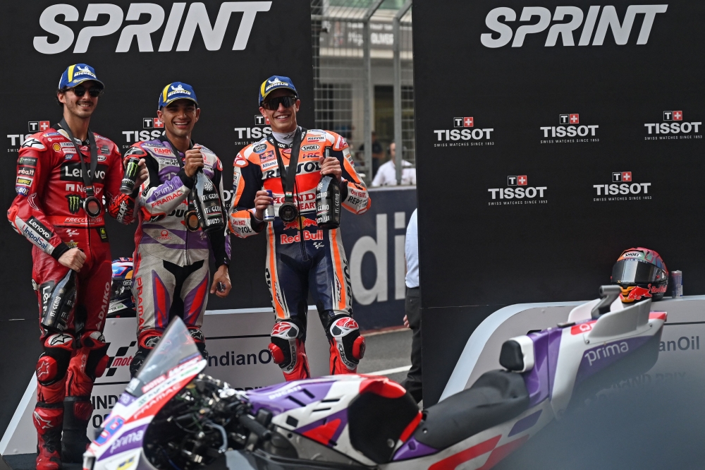 First placed Prima Pramac Racing's Spanish rider Jorge Martin (C), second placed Ducati Lenovo Team's Italian rider Francesco Bagnaia (L) and third placed Repsol Honda's Spanish rider Marc Marquez pose on the podium at the end of the sprint race of the Indian MotoGP Grand Prix. (Photo by Money Sharma/ AFP)