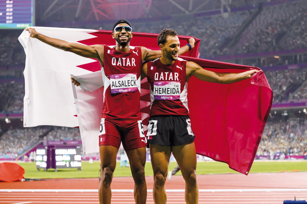 Qatar's Abderrahman Samba (left) and team-mate Bassem Hemeida celebrate after the men’s 400m hurdles final, yesterday. AFP