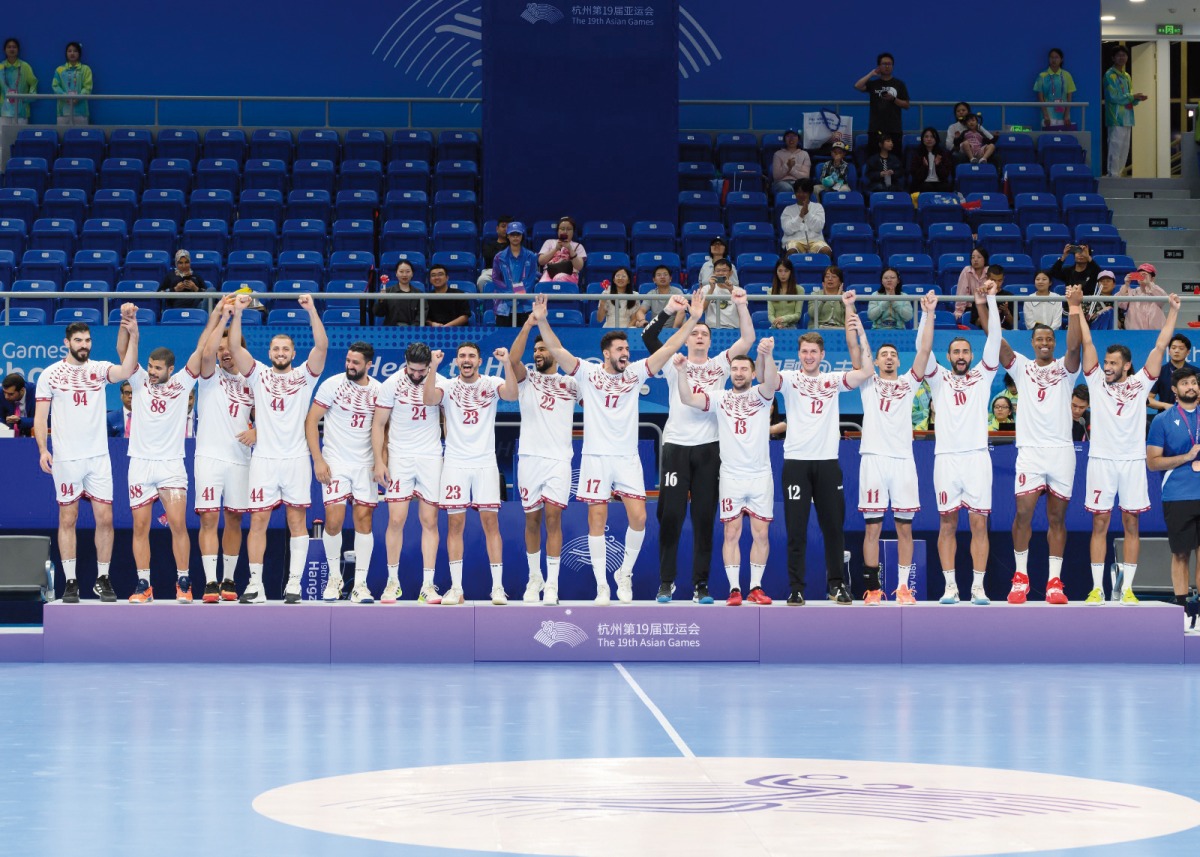 Qatar handball team members celebrate on the podium after winning the gold medal, yesterday.