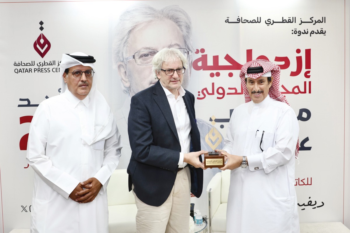 President of Qatar Press Center Saad bin Mohammed Al Rumaihi (right) and Director General of Qatar Press Center Sadiq Mohammed Al Amari (left) present a memento to Co-Founder and Editor-in-Chief of Middle East Eye David Hearst after the event.