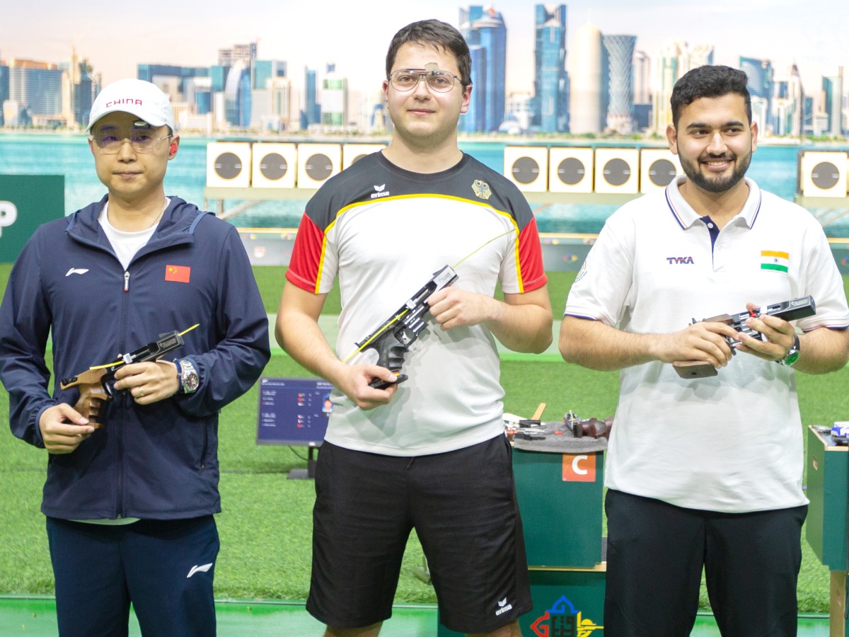 Winner, Germany's Peter Florian (centre), silver medallist Li Yuehong of China, and bronze medallist Anish Bhanwala of India pose for a photo after the Men's 25 meter rapid-fire pistol final. 